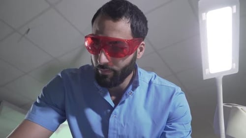 Bearded Doctor in Goggles Working in a Hospital