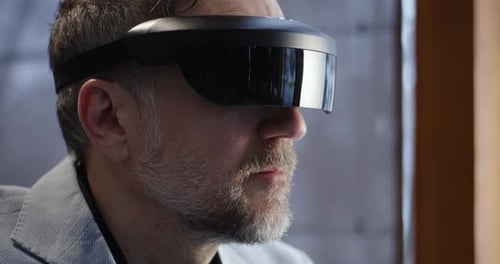Man Uses Augmented Reality Glasses in Office Setting
