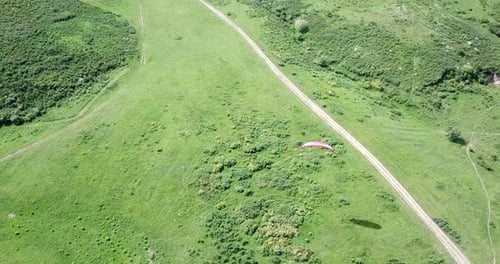 Paraglider Soaring Over Verdant Green Landscape, Aerial View