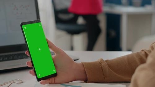 Close Up of Hand Holding Green Screen Vertically on Mobile Phone