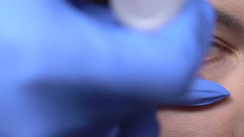 Woman's Eye Exam with Doctor in Blue Gloves
