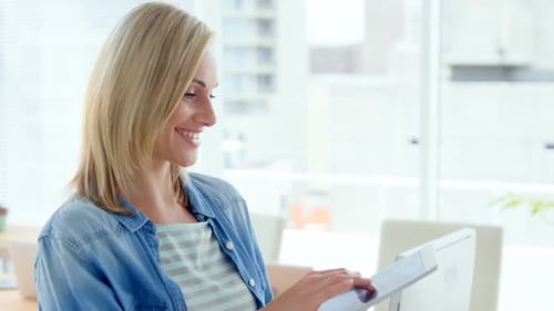 Young Woman Uses Tablet in Bright Modern Office