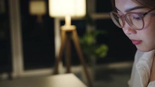 Woman Analyzing Graphs on Laptop at Night