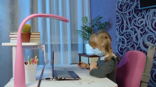 Child Learning at Desk with Laptop and Mask