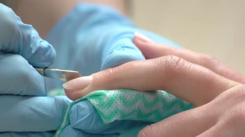 Manicurist Cleaning Nails To Young Woman.