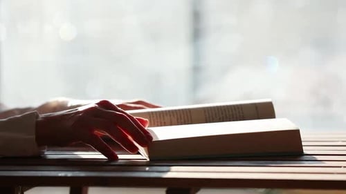 Femme en chemise blanche écrivant avec un stylo quelque chose dans un cahier.
