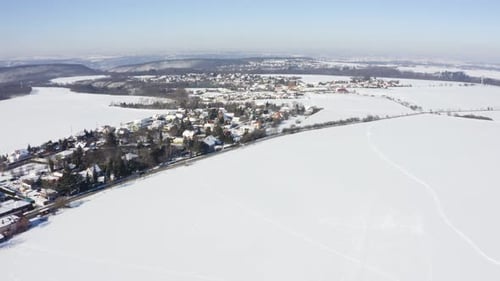Aerial Drone Shot Snowcovered Villages Fields and Forests in a Rural Area in Winter