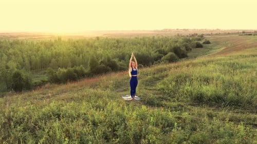 La femme fait du yoga. Dawn, Green Field.