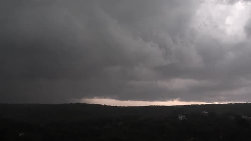 Dark Overcast Sky Over a Tree-Filled Horizon