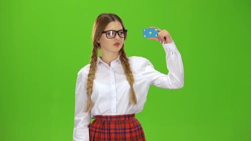 Schoolgirl in Glasses Shows a Finger Down . Green Screen