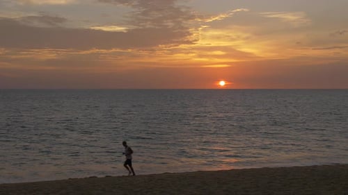 Man Running on Beach at Colorful Sunset