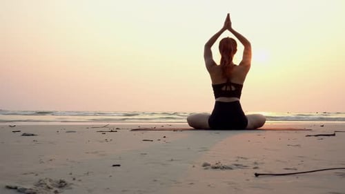 Slow motion of woman practice yoga lotus pose to meditation with summer vacation on the beach