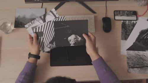 Top View of Photographer Looking at Printed Black and White Photos
