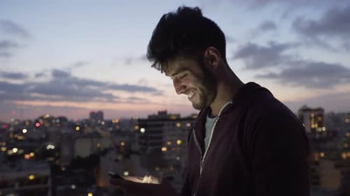 Man Using Mobile Phone on Rooftop at Night