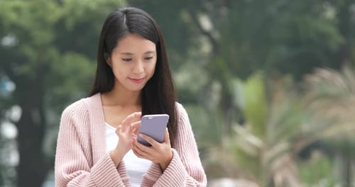 Smiling Woman Using Smartphone Outdoors