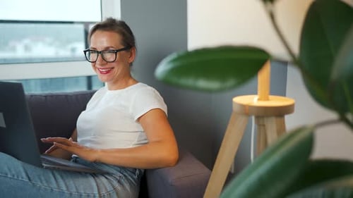 Woman Relaxing on Couch With Laptop