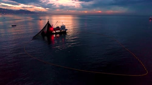 Fishing Boat Hauling Net at Ocean Sunrise
