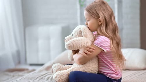 Sweet Girl Comforting Her Teddy Bear at Home