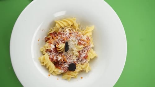 Adding Olives to Pasta with Tomato Sauce