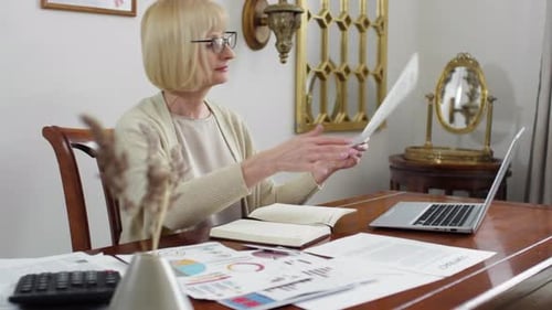 Middle-aged Businesswoman Working with Papers in Office