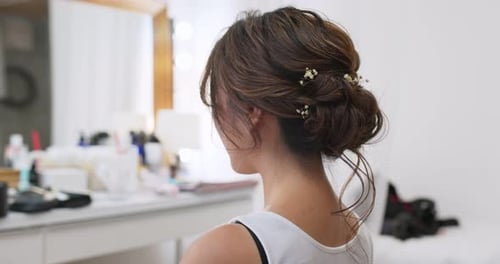 Hairdresser creating a hairstyle for bride in salon