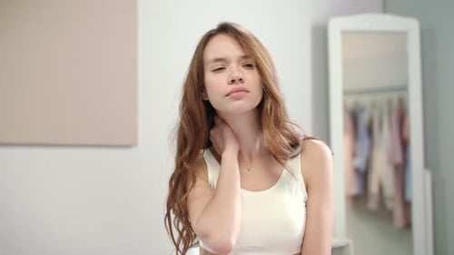 Woman Massaging Sore Neck Muscles Indoors