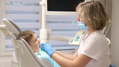 Dentist examines a child's teeth in modern office