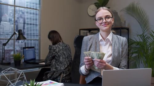 Businesswoman Receiving Money Cash Income From Laptop in Office After Successful Financial Deal