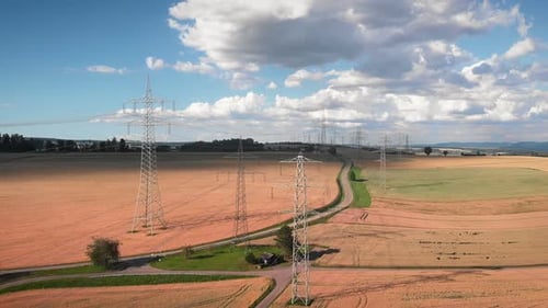 Electricity Pylons March Through Rural Fields