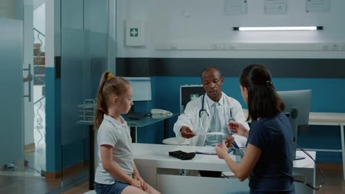 Doctor Talking to Mother and Child in Office