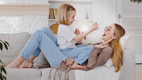 Happy Child and Mother Bonding on Couch