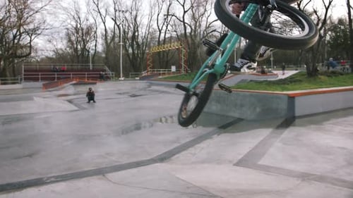 BMX Rider Doing Tricks in Street Plaza Bicycle Stunt Rider in Cocncrete Skatepark Super Slow Motion