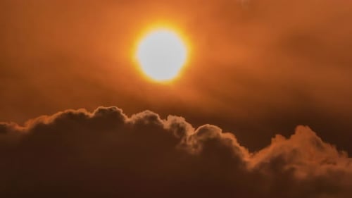Sun Setting Behind Golden Cumulus Clouds