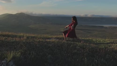 Woman Dancing Barefoot on Hilltop at Sunset