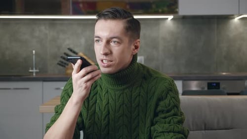 Young Adult Talking on Smartphone in Kitchen