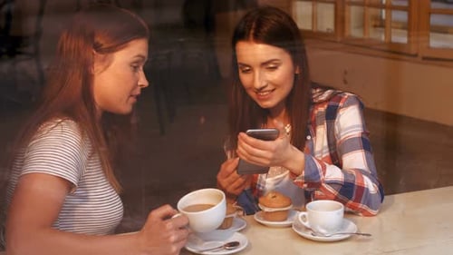 Women Friends Enjoying Coffee and Phone in Cafe