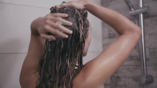 Woman Washing Curly Hair in Bright Shower