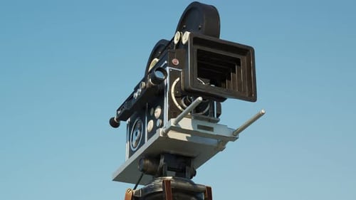 Classic Film Camera Rotating on a Blue Sky Background