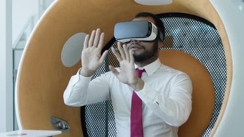Man Using VR Headset in Modern Office Chair