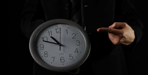 Geschäftsmann zeigt Zeit auf Uhr (schwarz)