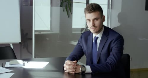 Handsome Young Professional Smiling in Modern Office