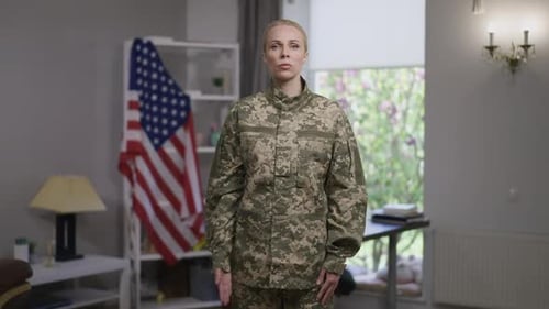 Woman in Military Uniform Saluting Flag Indoors