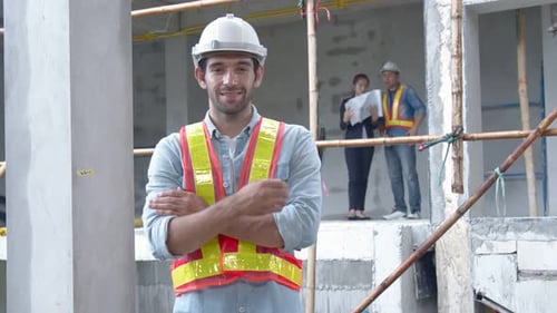 Smiling Construction Worker With Arms Crossed At Building Site