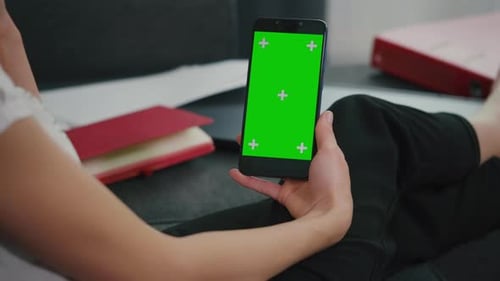 Back View of Woman at Phone with Green Screen for Copy Space.