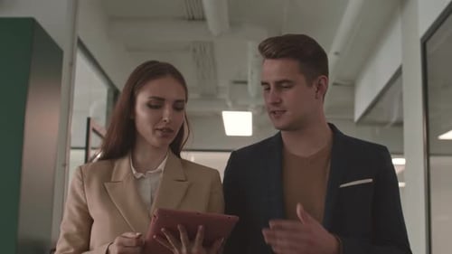 Two Colleagues Going along Office and Talking