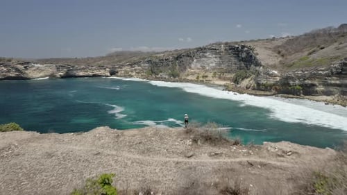 Scenic Aerial Shot of Mountainous Cliffs, Ocean Horizon, Beach, and Blue Sky