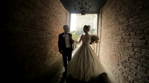 Bride and Groom Walking Through Brick Tunnel