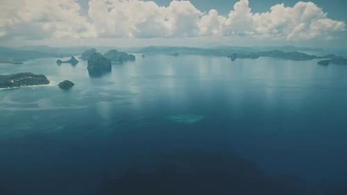 Blue Ocean Bay mit Mountain Island an der Wasseroberfläche. Ruhige Meereslandschaft mit flauschiger Wolkenreflexion
