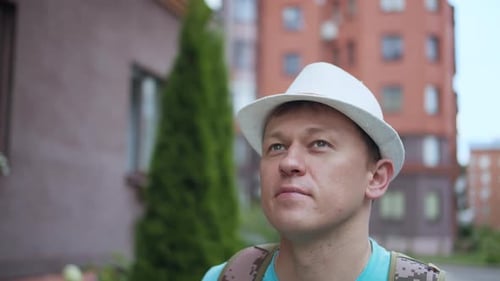 Young Attractive Man in Hat Walking in the City Camera Tracking