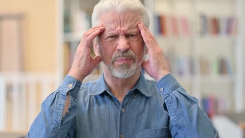 Senior Man Massaging Temples Due to Headache